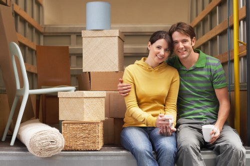 Professional movers carrying furniture through a Brentford home